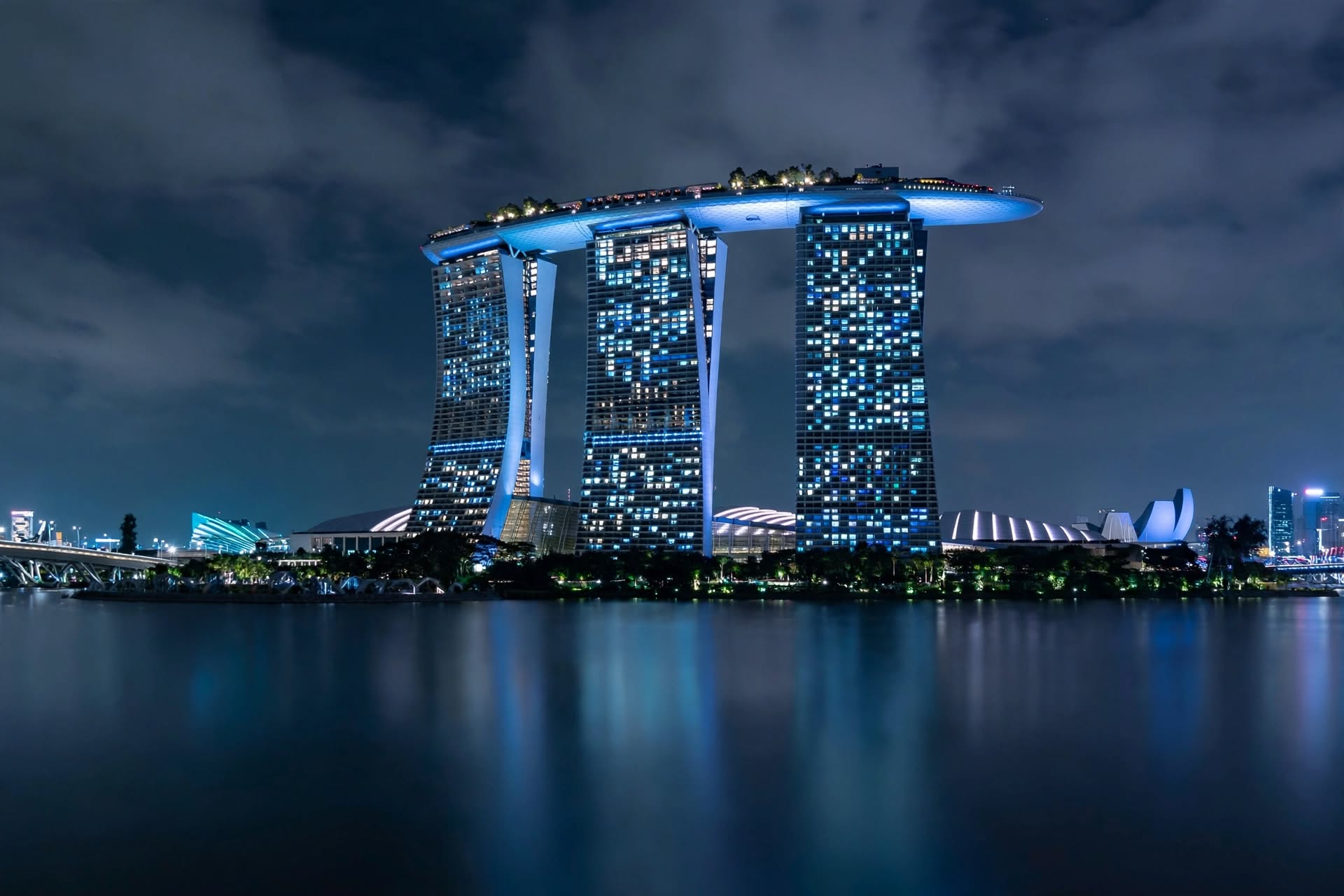 Iconic three-tower resort complex crowned with cantilevered rooftop observation deck over urban bay